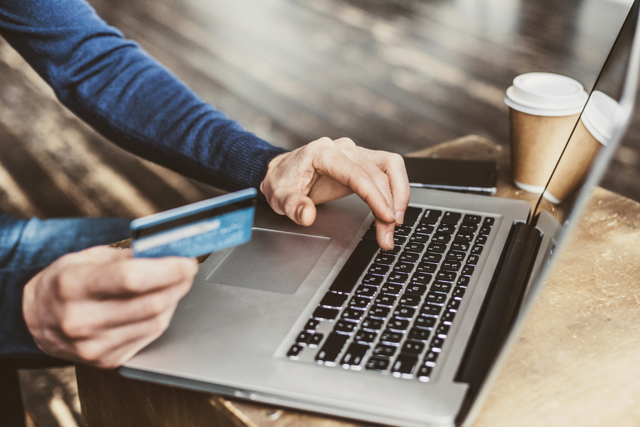 Internet shopper entering credit card information using laptop computer keyboard. Online shopping concept