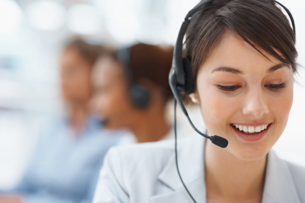 Beautiful customer representative with headset smiling during a telephone conversation