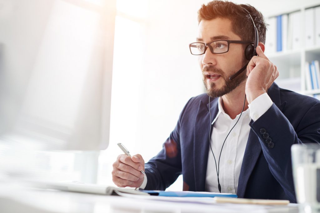 Tech support manager in headset consulting a client