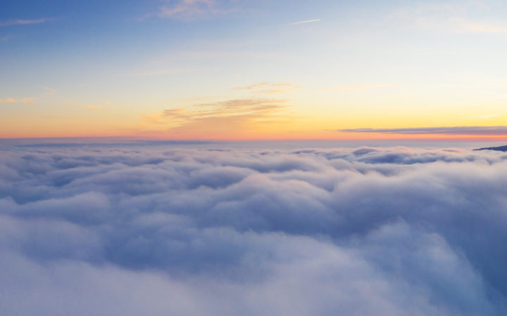 Beautiful sunrise cloudy sky from aerial view. Airplane view above clouds