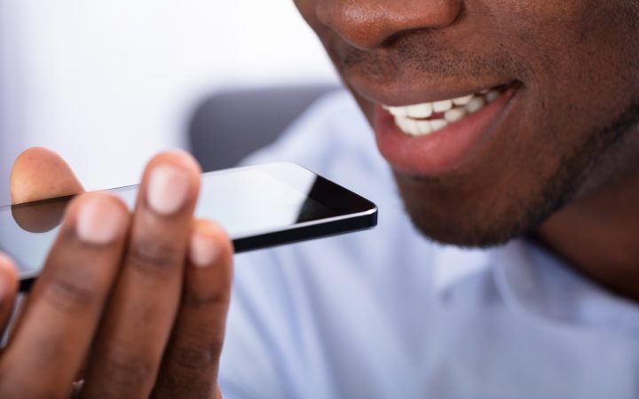 Close-up Of An African Man Using Voice Assistant On Cellphone