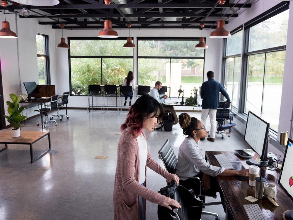 Several mid adult people share a co-working space to do freelance work or finish projects.