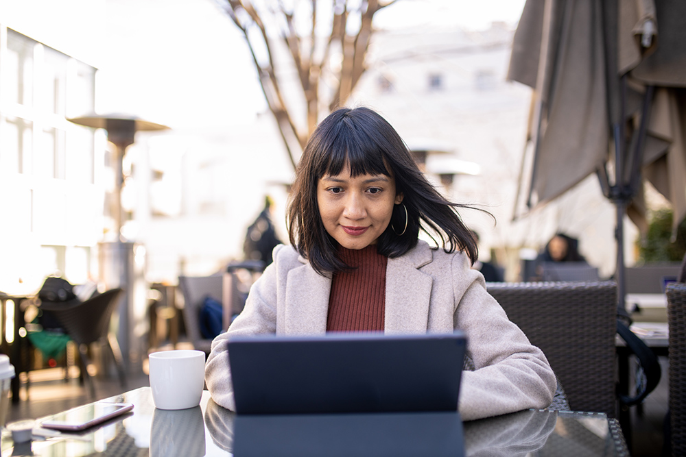 Asian woman working at outdoor cafe