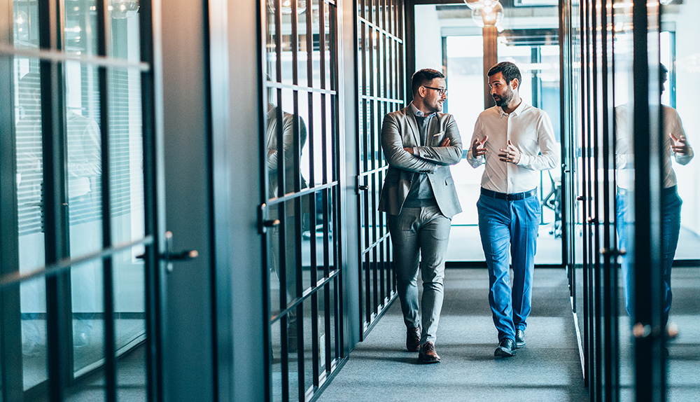 Business people walking and talking discussing ideas in the office