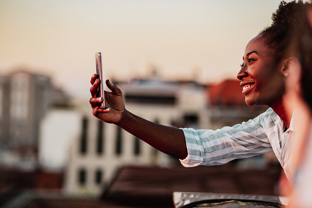 Young African American woman is on the balcony at sunset