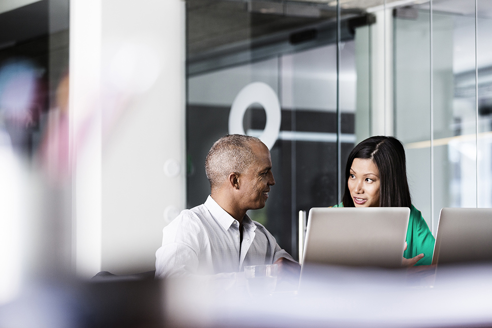 Multi-ethnic business people discussing at desk in office