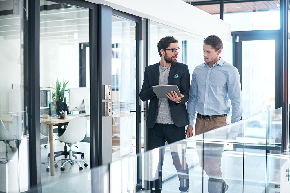 Shot of two businessmen using a digital tablet together in an office