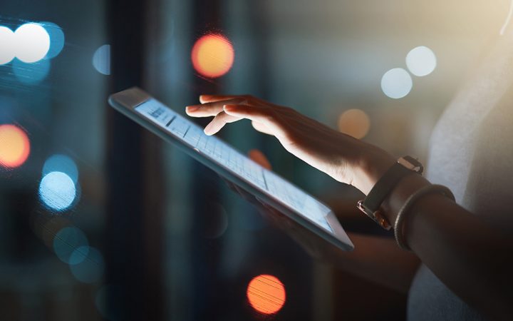 Cropped shot of an unrecognizable businesswoman using a digital tablet while working late