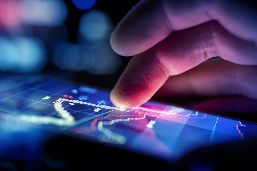 A city businessman using a mobile device to check stocks and market data. Close up shot.