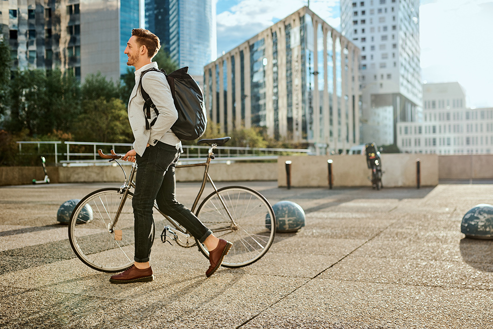 Shot of a young businessman traveling through the city with his bicycle