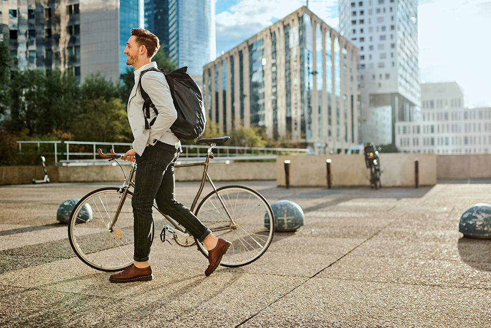 Time to kick this workday into high gear Shot of a young businessman traveling through the city with his bicycle