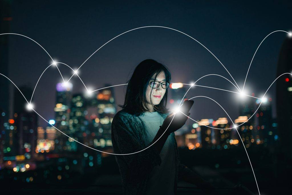 Social Connecting in smart city at Night woman in the city using a tablet showing digital connection