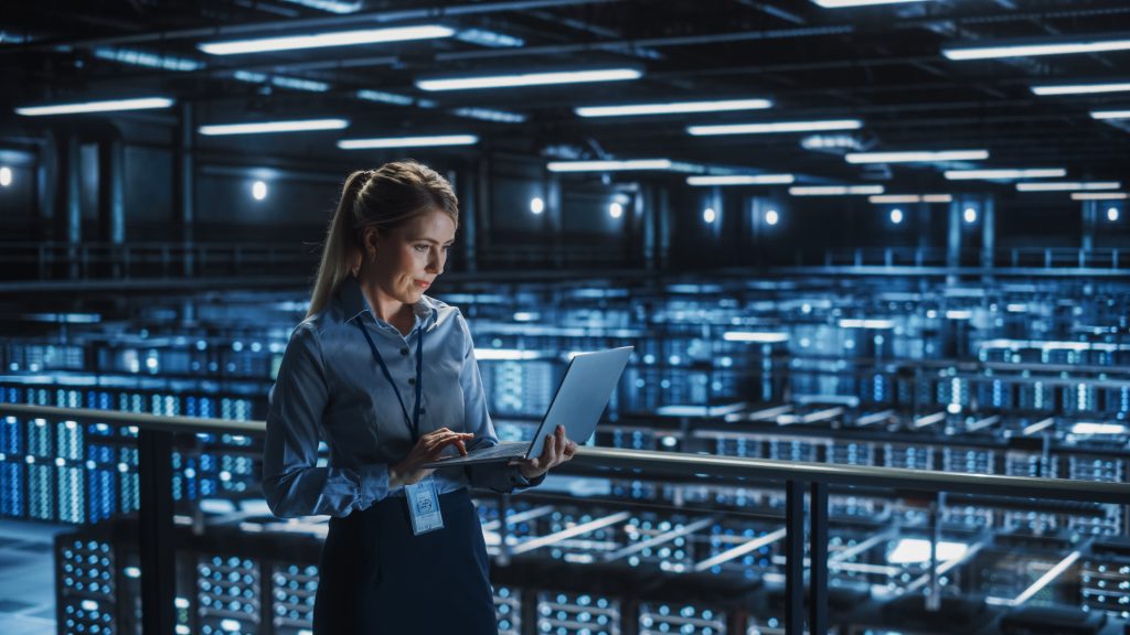 Person on a laptop in a large data centre