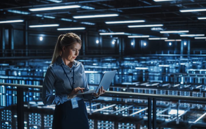 Person on a laptop in a large data centre