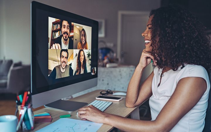 Lady smiling in front of monitor on videoconference