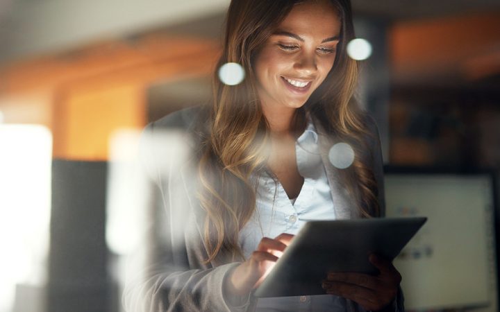 A friendly-looking woman scrolls through an iPad, representing a company with a good net promotor score