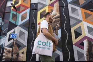 This man is walking past a data centre with his laptop.