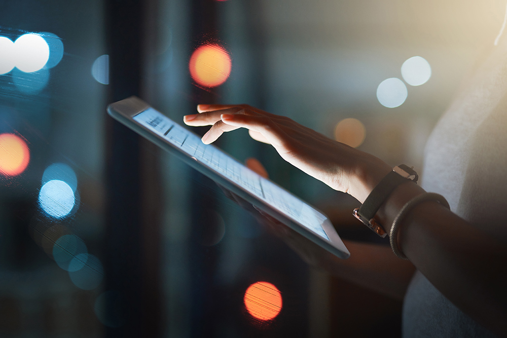 Staying in the loop is compulsory Cropped shot of an unrecognizable businesswoman using a digital tablet while working late