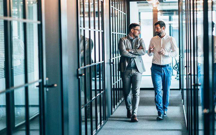 Business partners in discussion walking in office