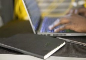 While this man works, his notebook sits beside him