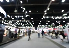 Blurred, defocused background of public exhibition hall. Business tradeshow or stock market, organization or company event, commercial trading fair, or shopping mall marketing advertisement concept